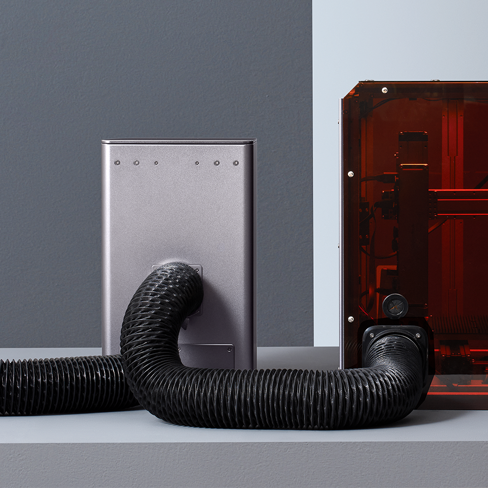 Detailed view of Snapmaker Air Purifier with HEPA filter connected to the 3D printer via hose.